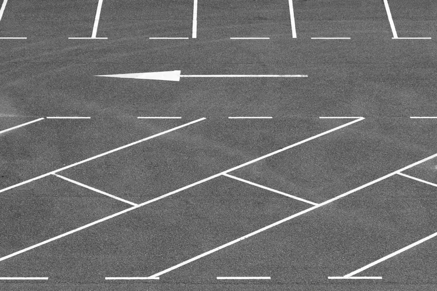 Parking lot with painted directional arrow and stall lines